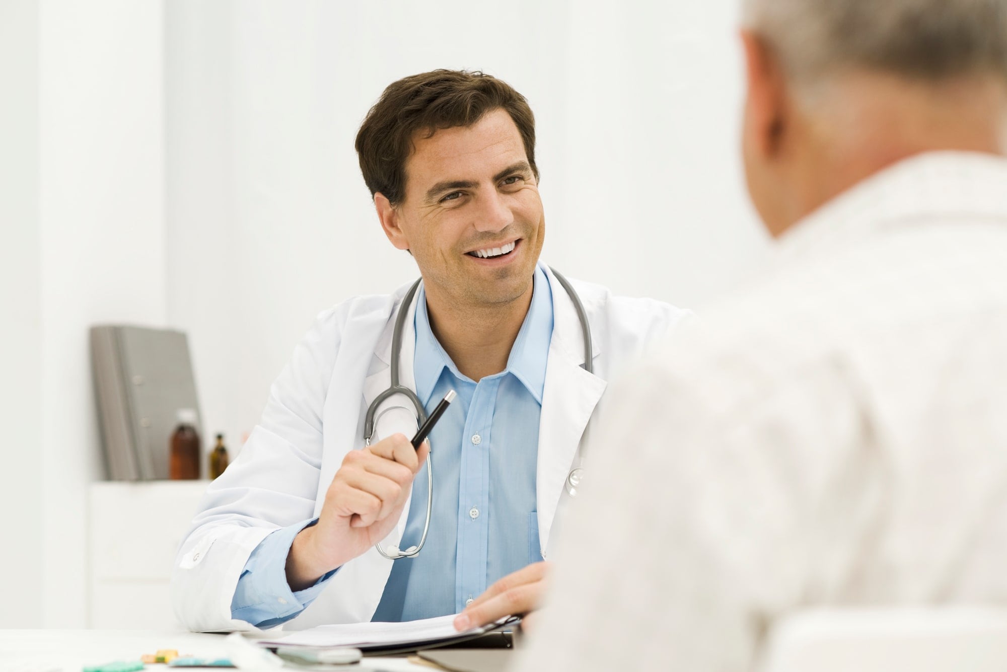 Un médico conversando con un paciente en un entorno clínico, mostrando atención y profesionalismo