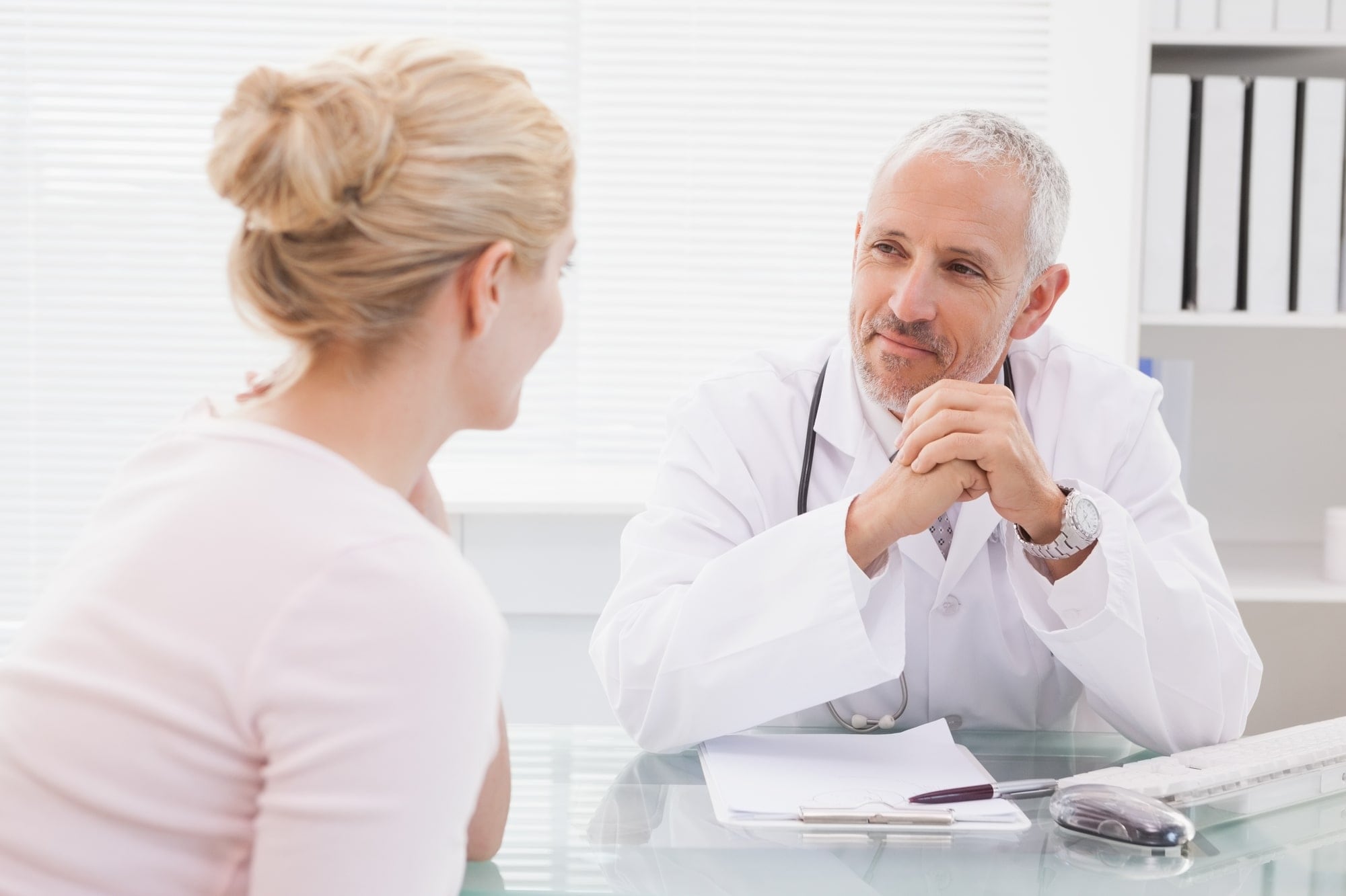 Un médico conversando con un paciente en un entorno clínico, mostrando atención y profesionalismo