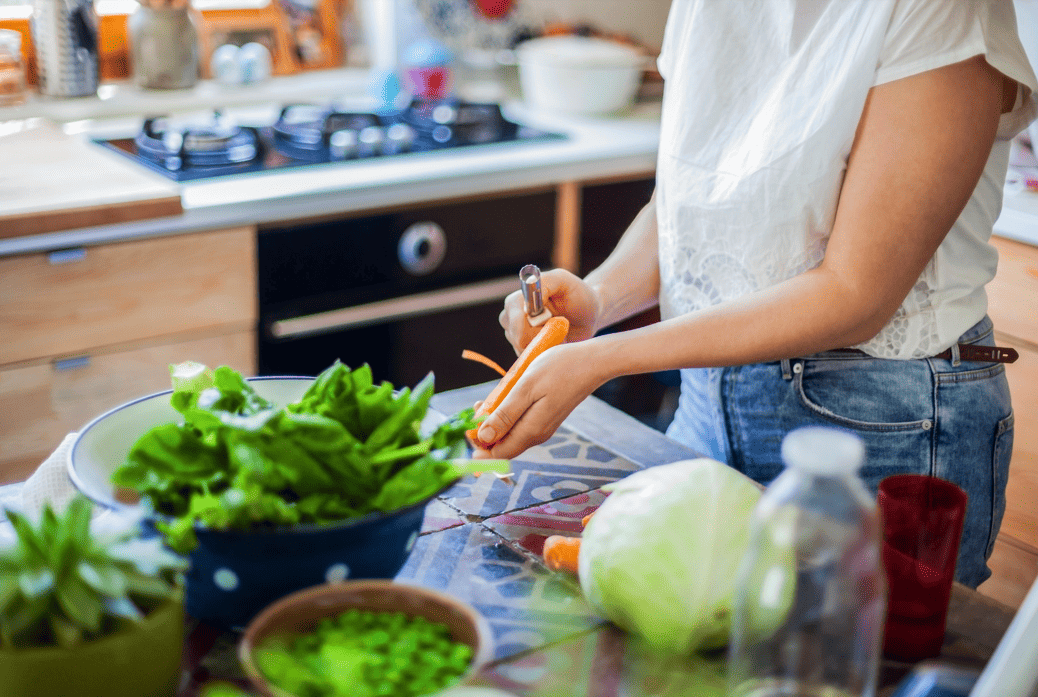 Mujer preparando vegetales frescos, destacando ingredientes ricos en fibra y omega-3.