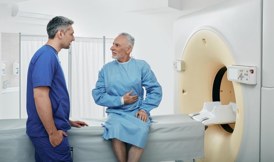 Un profesional de la salud con un hombre adulto conversan, mostrando atención y profesionalismo en la interacción.